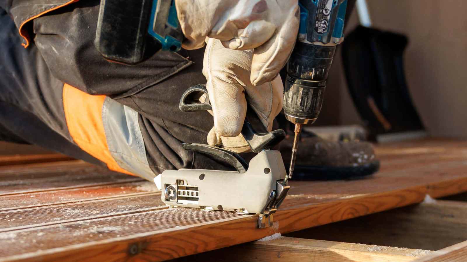 Vlonder repareren door Vlonderhoud Vakman monteert een vlonderplank met montageclip en accuschroefmachine — vlonder repareren door Vlonderhoud